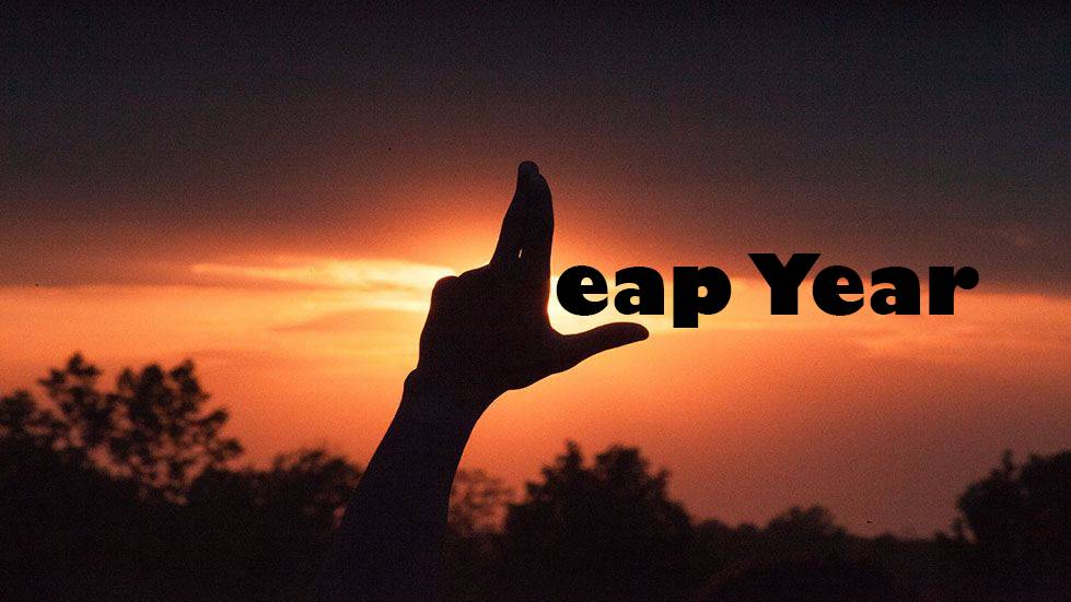 Student's hand formed as the Laker el against an oragen sunset with letters added to read Leap Year.